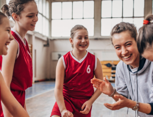 Female coach encouraging girls basketball team
